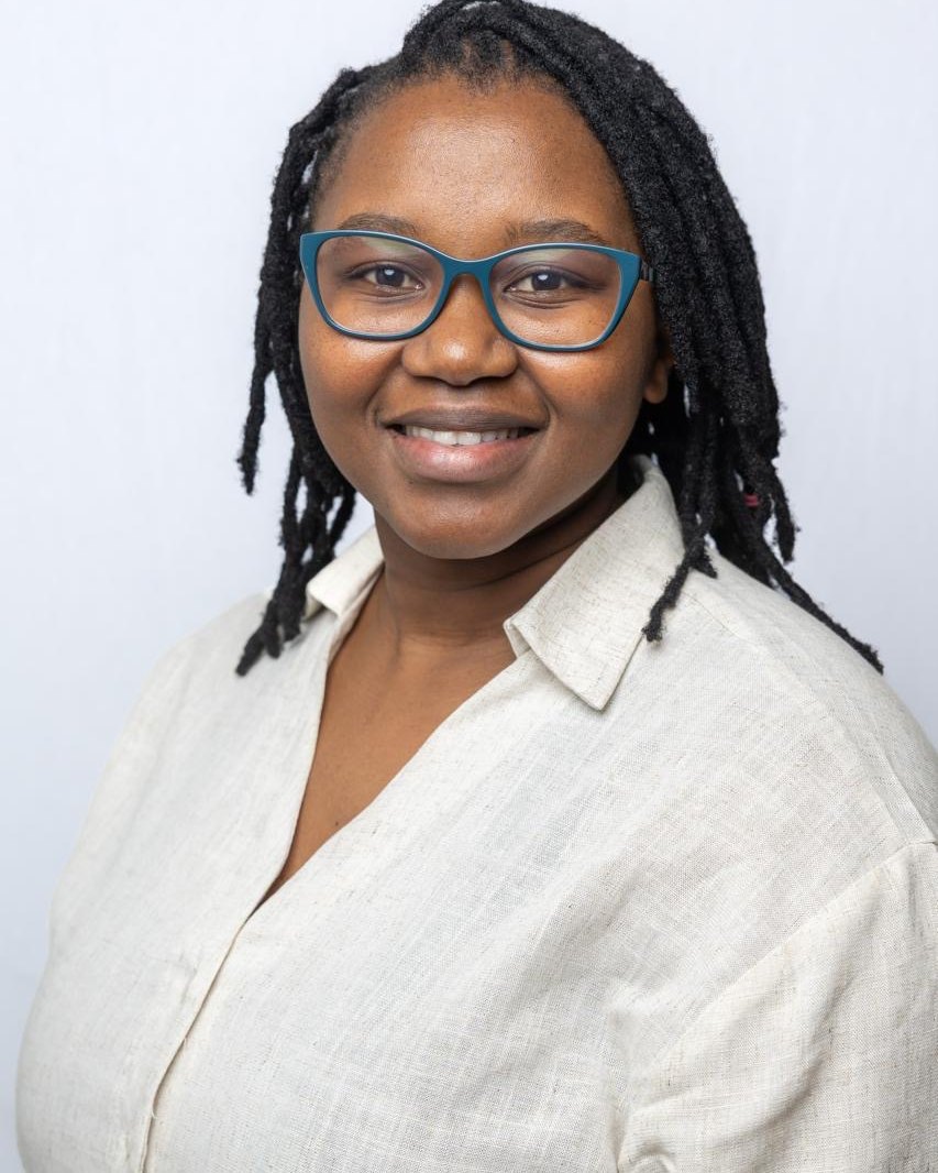Dr Zimvo Obasa in a light linen shirt and teal glasses.